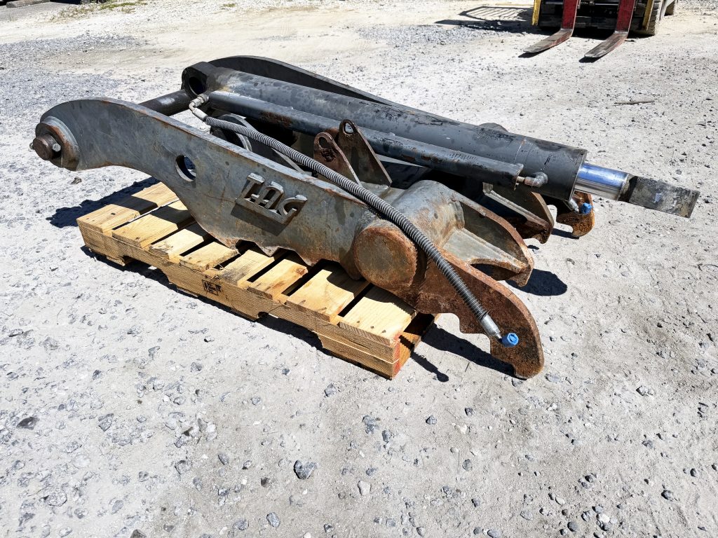Used heavy-duty TAG Manufacturing 64-inch hydraulic main-pin excavator thumb, featuring 80mm pin bores, 20-inch ear width, and serrated dual tines for 20-ton class machines.