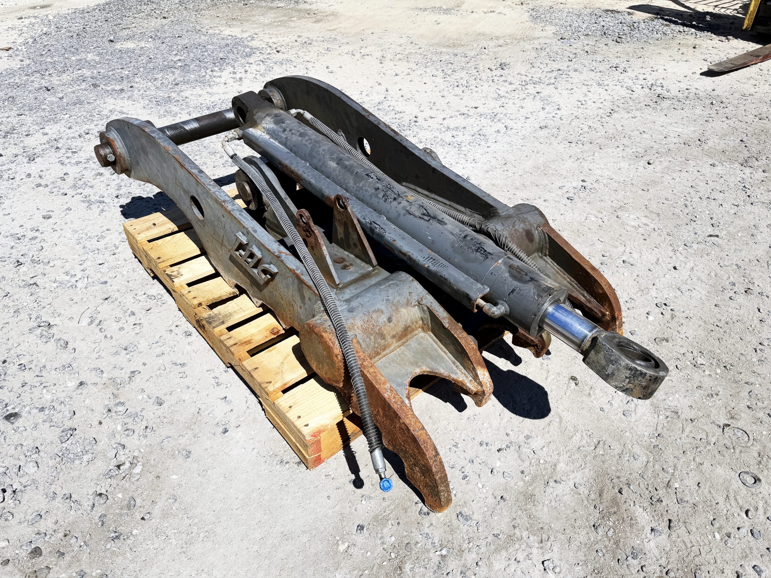 Used heavy-duty TAG Manufacturing 64-inch hydraulic main-pin excavator thumb, featuring 80mm pin bores, 20-inch ear width, and serrated dual tines for 20-ton class machines.