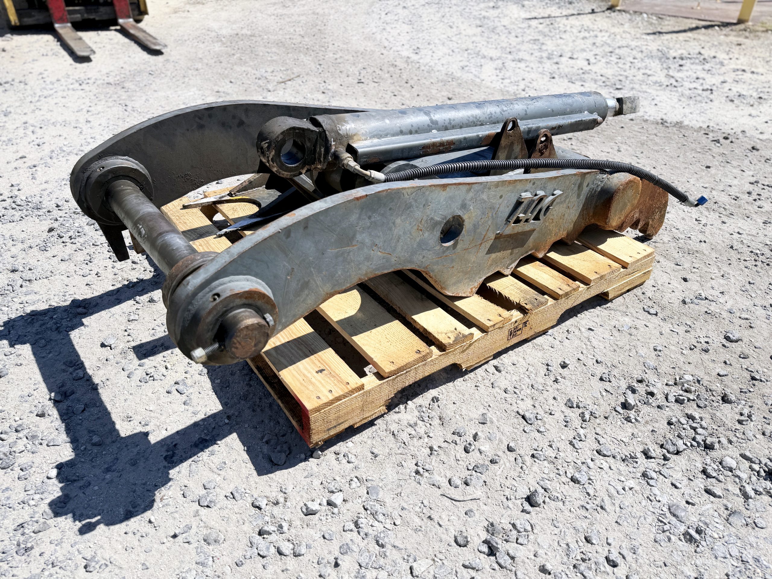 Used heavy-duty TAG Manufacturing 64-inch hydraulic main-pin excavator thumb, featuring 80mm pin bores, 20-inch ear width, and serrated dual tines for 20-ton class machines.