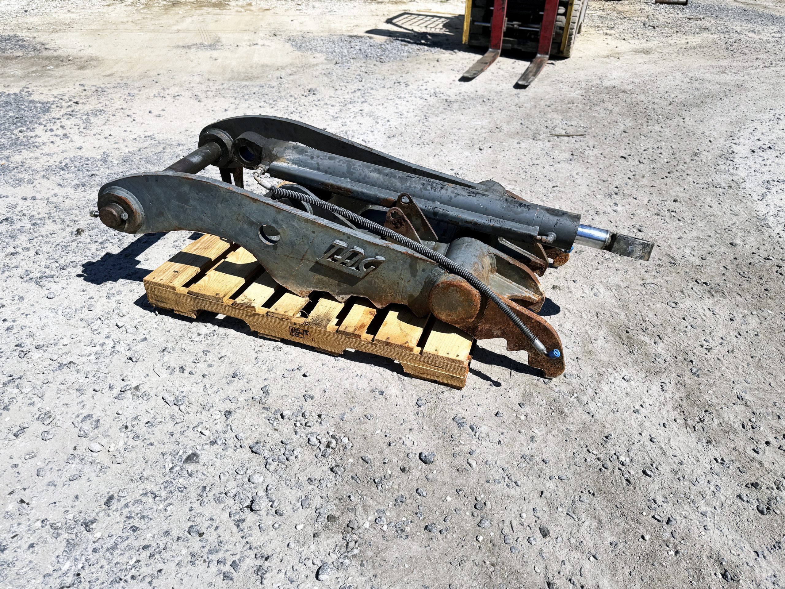 Used heavy-duty TAG Manufacturing 64-inch hydraulic main-pin excavator thumb, featuring 80mm pin bores, 20-inch ear width, and serrated dual tines for 20-ton class machines.
