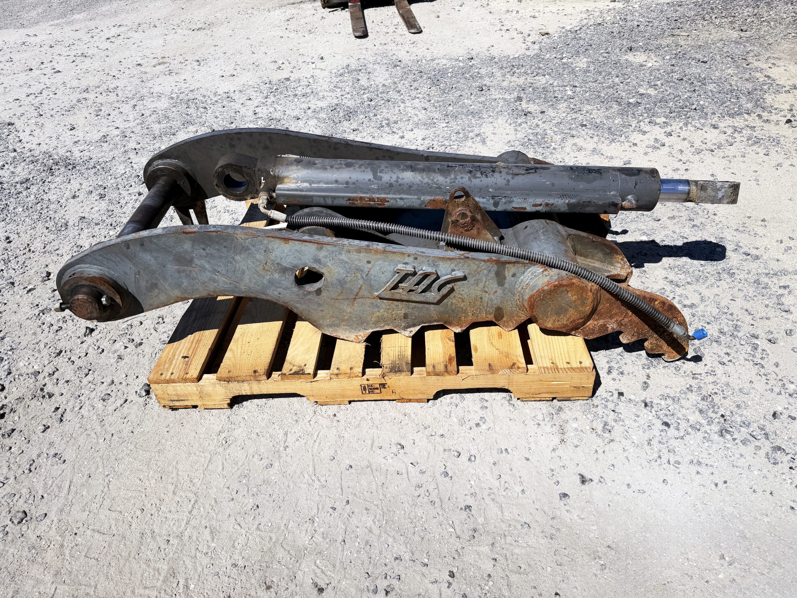 Used heavy-duty TAG Manufacturing 64-inch hydraulic main-pin excavator thumb, featuring 80mm pin bores, 20-inch ear width, and serrated dual tines for 20-ton class machines.