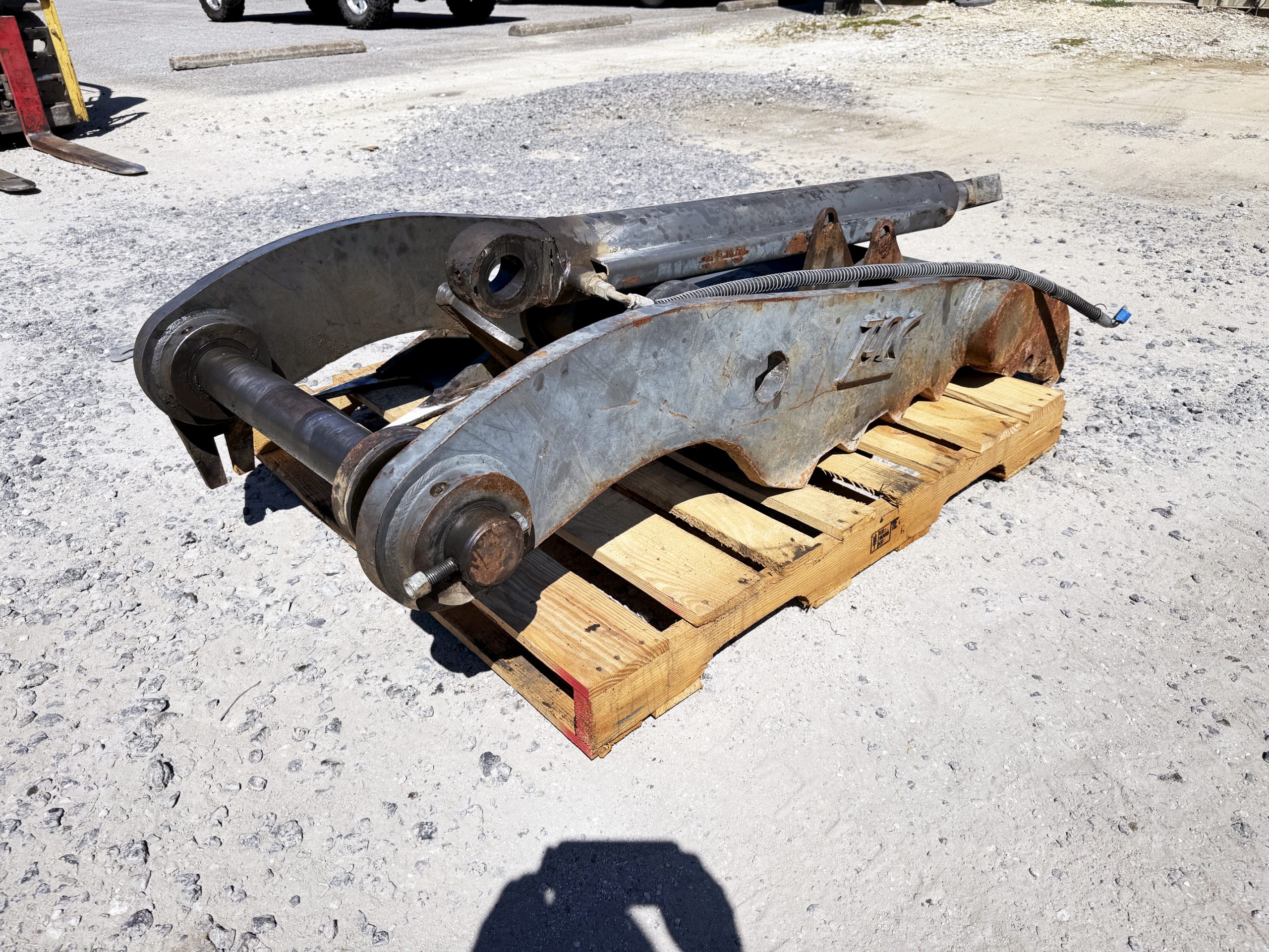 Used heavy-duty TAG Manufacturing 64-inch hydraulic main-pin excavator thumb, featuring 80mm pin bores, 20-inch ear width, and serrated dual tines for 20-ton class machines.