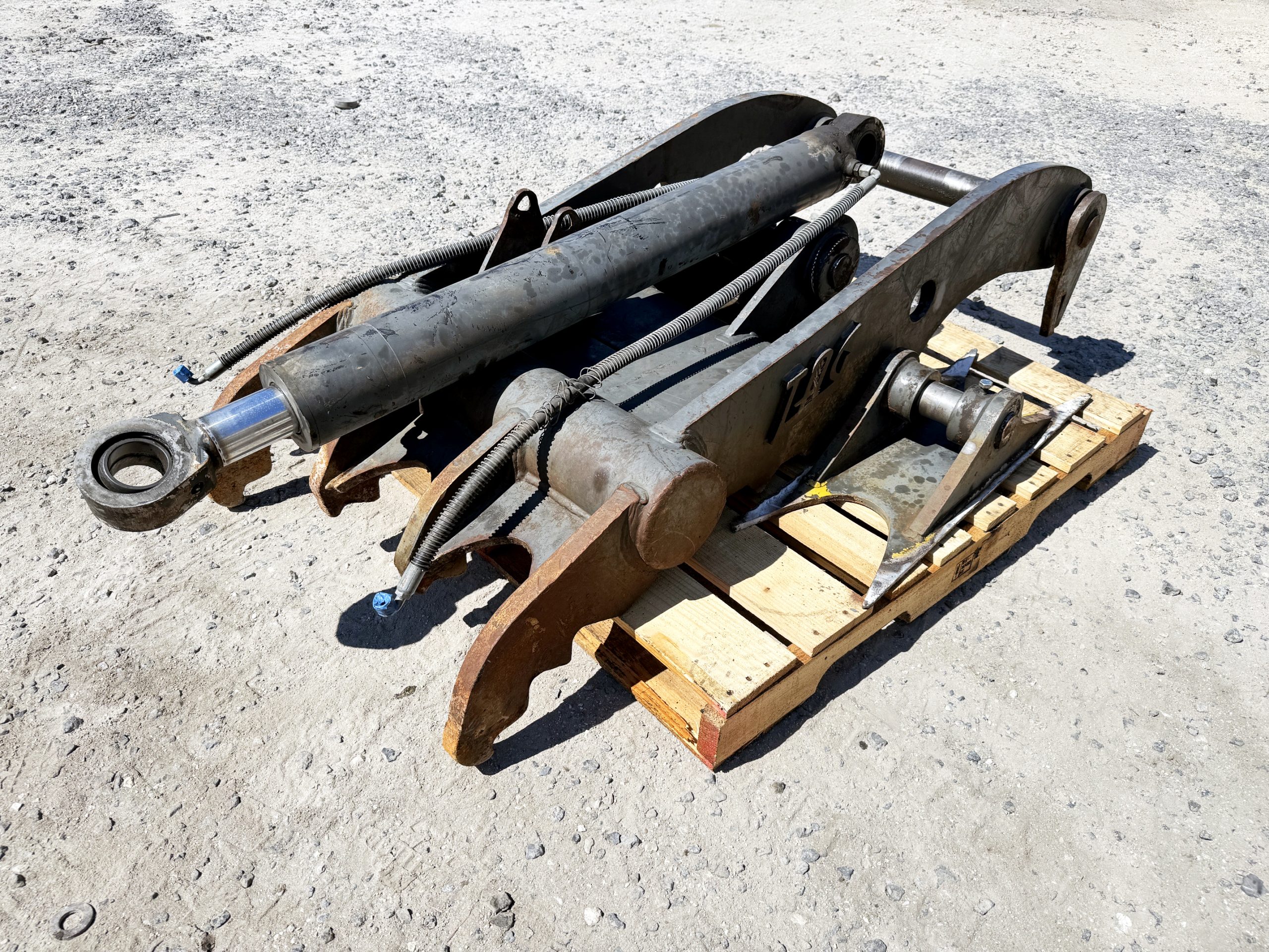 Used heavy-duty TAG Manufacturing 64-inch hydraulic main-pin excavator thumb, featuring 80mm pin bores, 20-inch ear width, and serrated dual tines for 20-ton class machines.