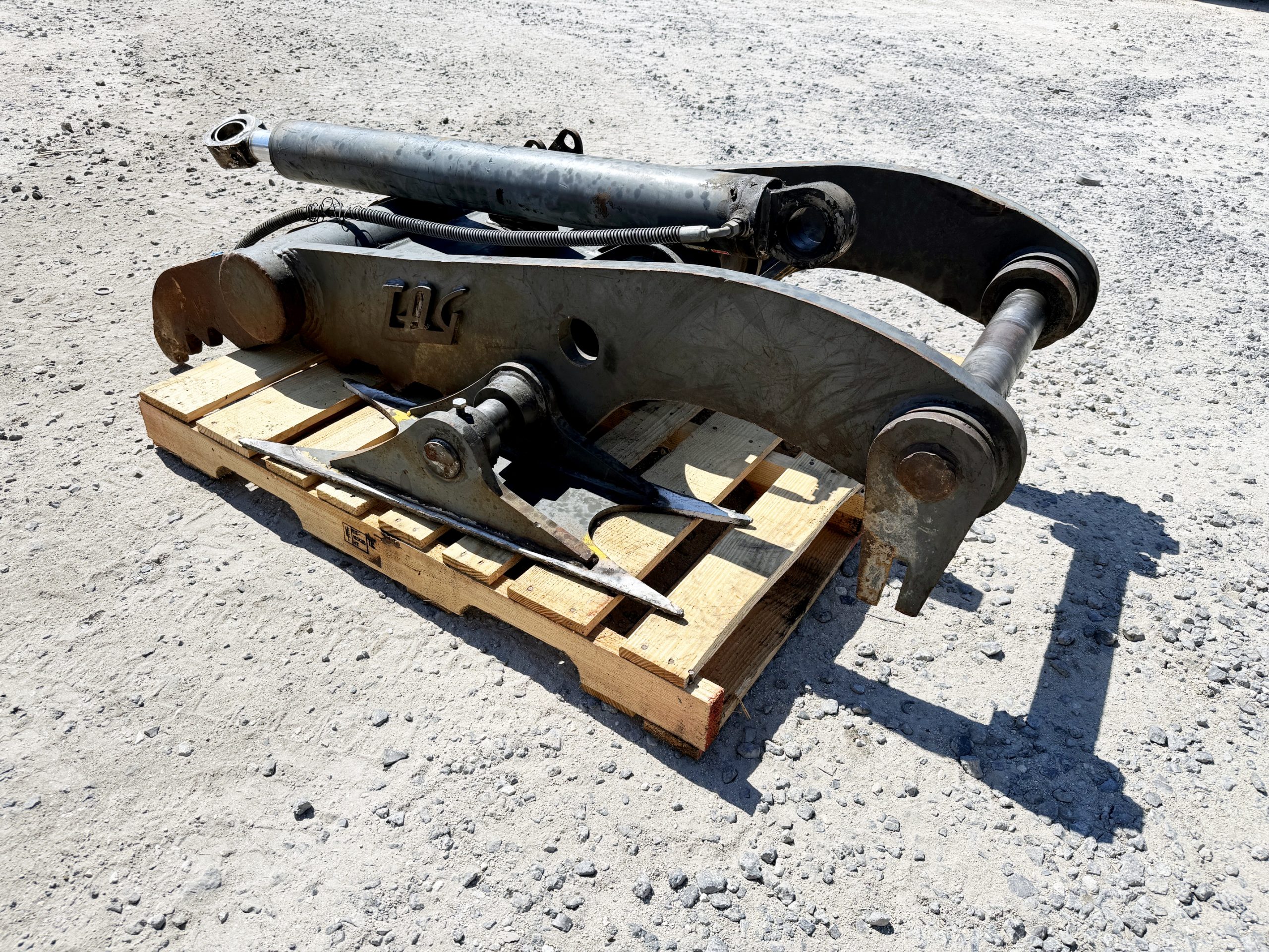 Used heavy-duty TAG Manufacturing 64-inch hydraulic main-pin excavator thumb, featuring 80mm pin bores, 20-inch ear width, and serrated dual tines for 20-ton class machines.